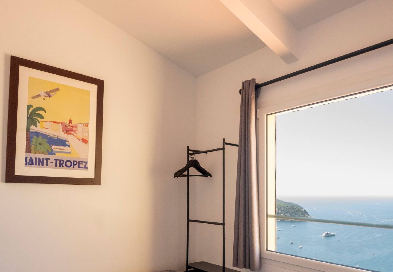 Lit simple avec portant, cadre et fenêtre vue mer