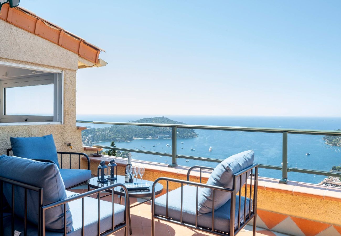 Terrasse ensoleillée avec mobilier d’extérieur et vue sur la mer