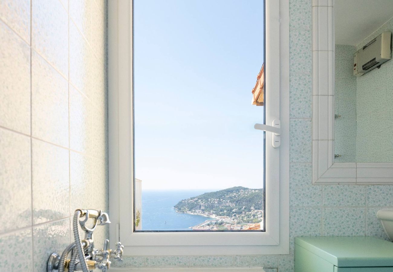 Baignoire située dans la salle de bain avec une fenêtre donnant vue sur la mer