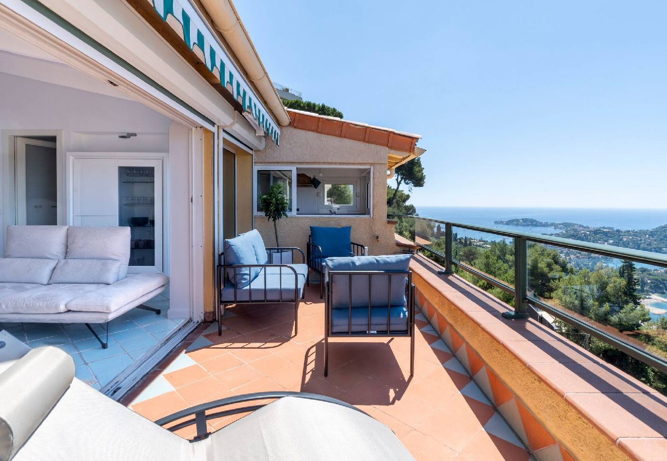 Terrasse avec mobilier de jardin, transat, store et vue sur la mer