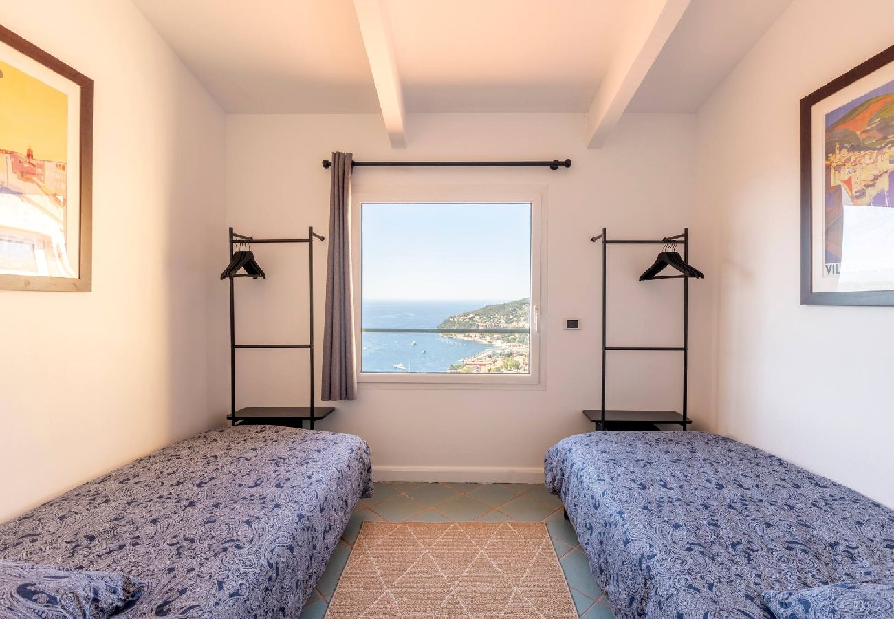 Chambre avec deux lits simples, deux portant, une fenêtre avec vue mer