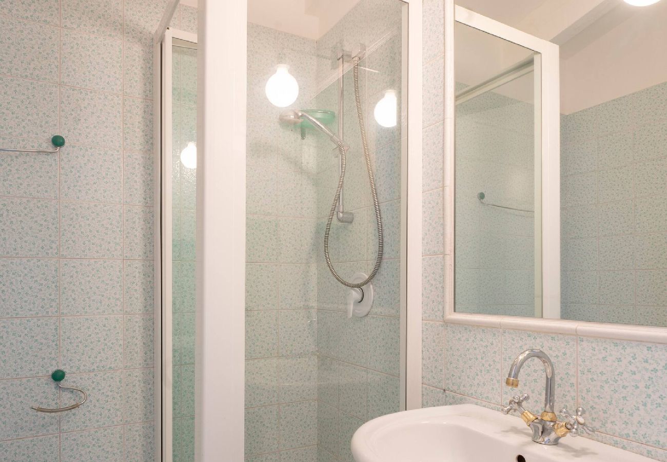 Salle de bain avec lavabo, miroir, douche et toilette