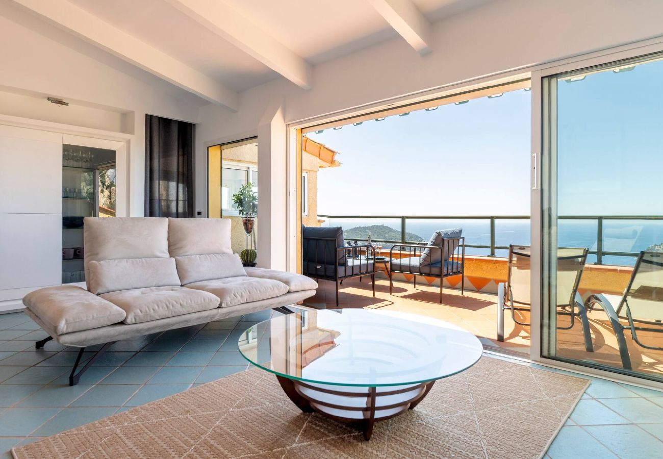 Salon lumineux avec canapé et table basse donnant vu sur la mer