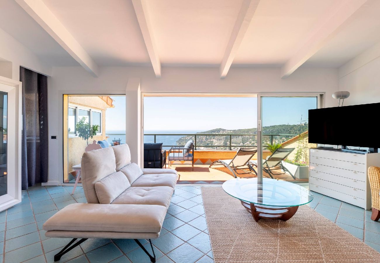 Salon aménagé avec canapé et table basse et vue sur la mer